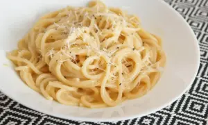 Pyszny makaron z serem, posypany świeżo startym parmezanem i pieprzem. Idealny na szybki obiad.