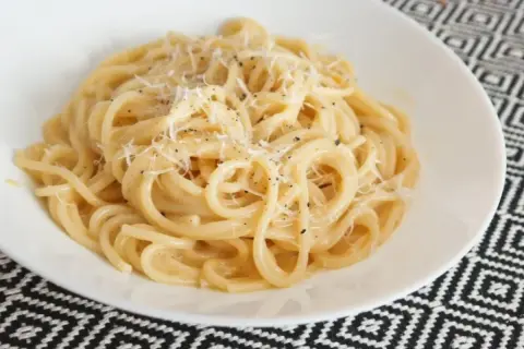 Pyszny makaron z serem, posypany świeżo startym parmezanem i pieprzem. Idealny na szybki obiad.