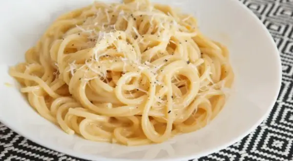Pyszny makaron z serem, posypany świeżo startym parmezanem i pieprzem. Idealny na szybki obiad.