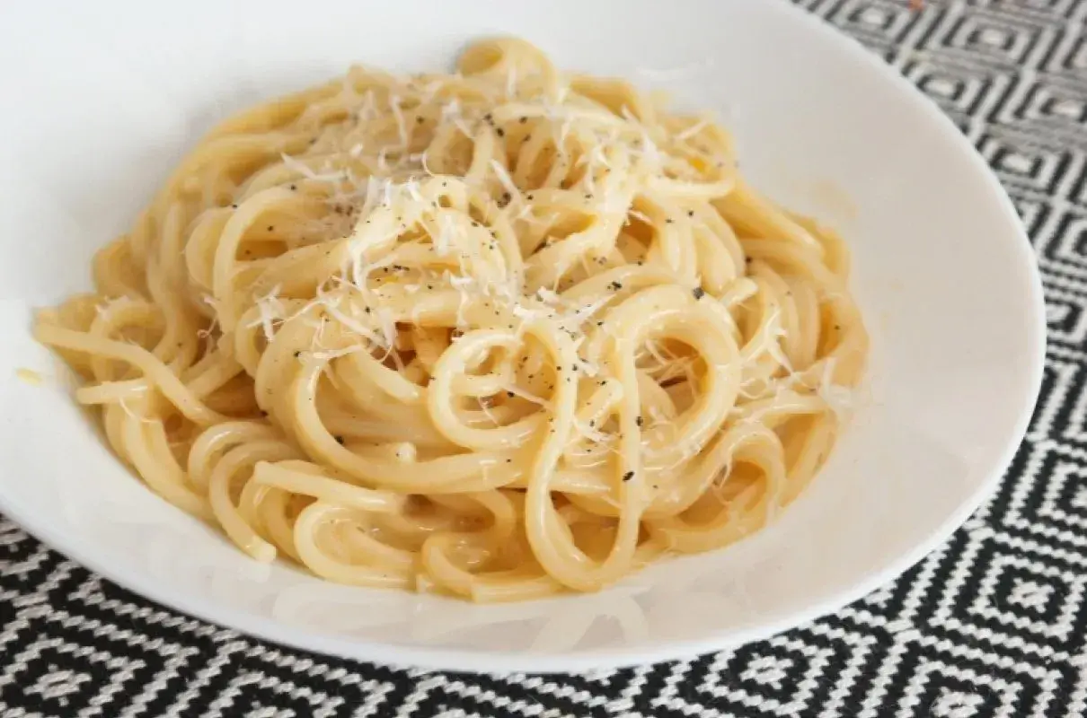 Pyszny makaron z serem, posypany świeżo startym parmezanem i pieprzem. Idealny na szybki obiad.
