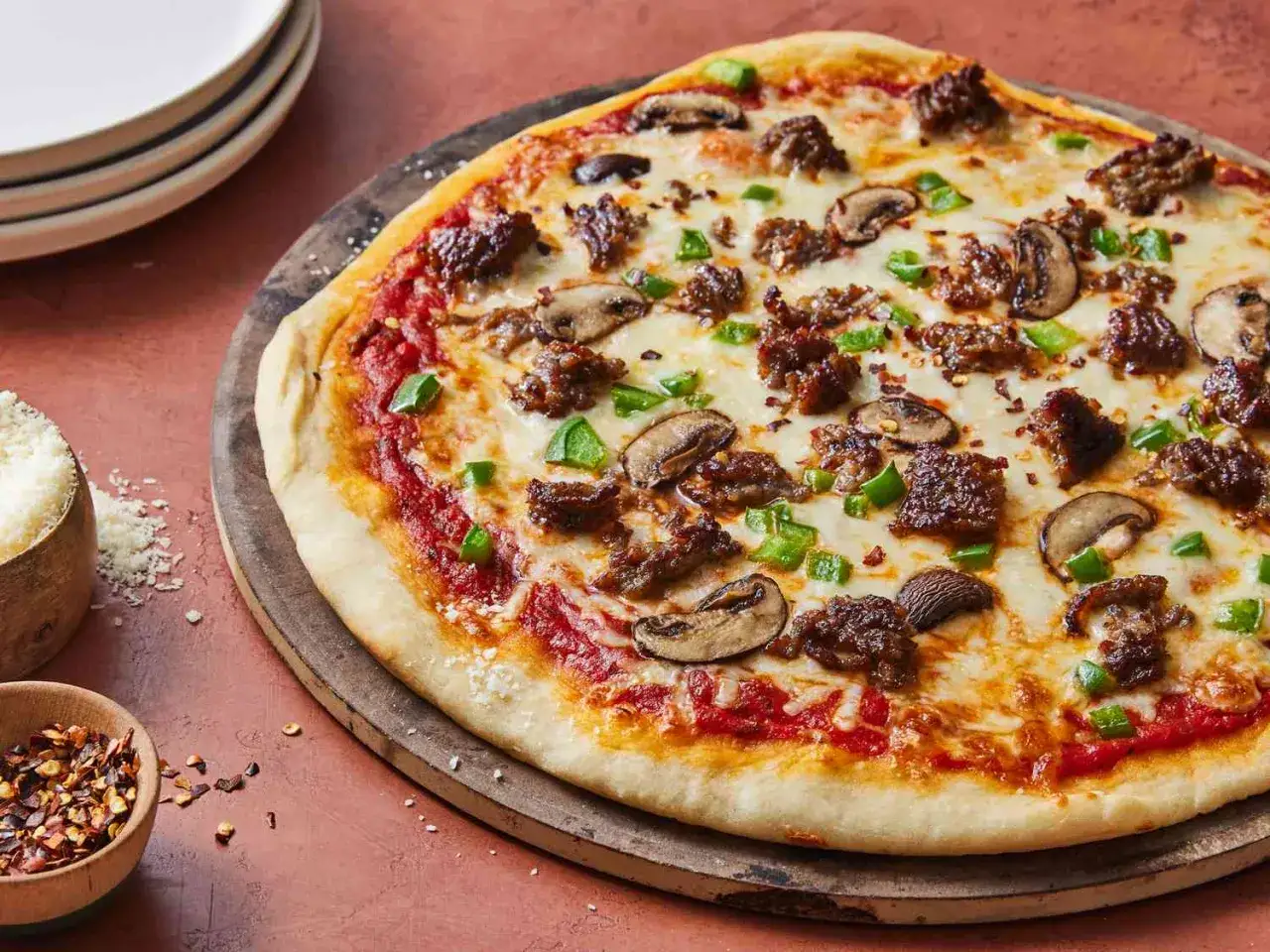 Pyszna pizza na cienkim cieście z mięsem mielonym, pieczarkami i papryką. Idealna na szybki obiad.