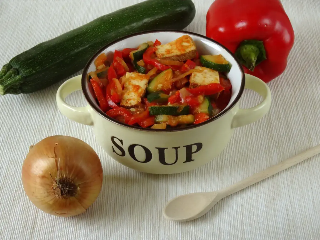 Pyszne leczo z tofu, papryką, cukinią i cebulą w misce z napisem