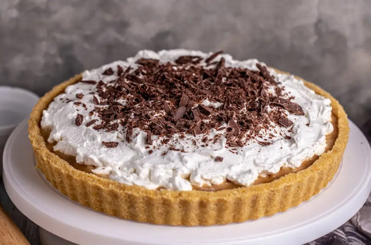 Pyszna tarta Kinder Bueno z kremem i wi&oacute;rkami czekolady, idealna na deser.