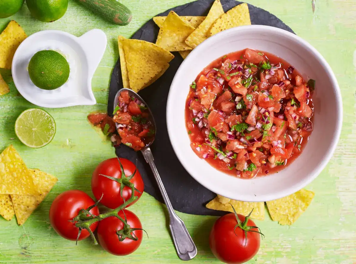 Świeża salsa z pomidorów, cebuli i kolendry, podana z nachos i limonką. Idealna na przekąskę!
