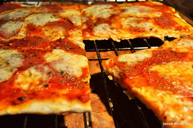 Pyszna pizza na cienkim cieście, z ciągnącym się serem i aromatycznym sosem pomidorowym, prosto z pieca.